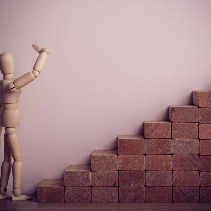 Wooden Figure Contemplating Climbing Stairs