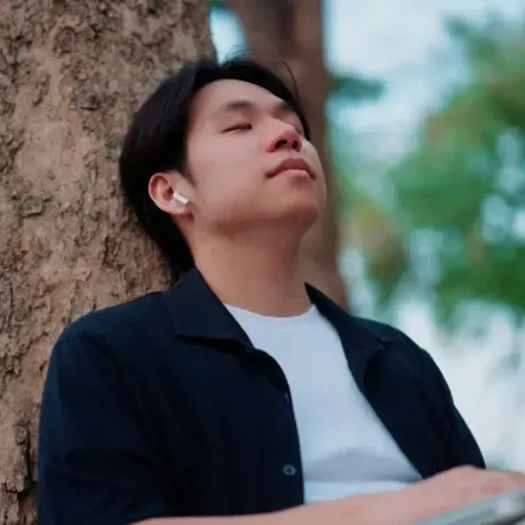 Man meditating at a tree.