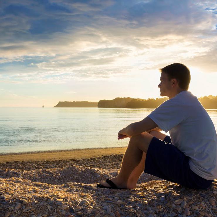 Photo of a man looking out at water via Istock